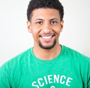 Portrait of a smiling young man wearing a green T-shirt with science text.